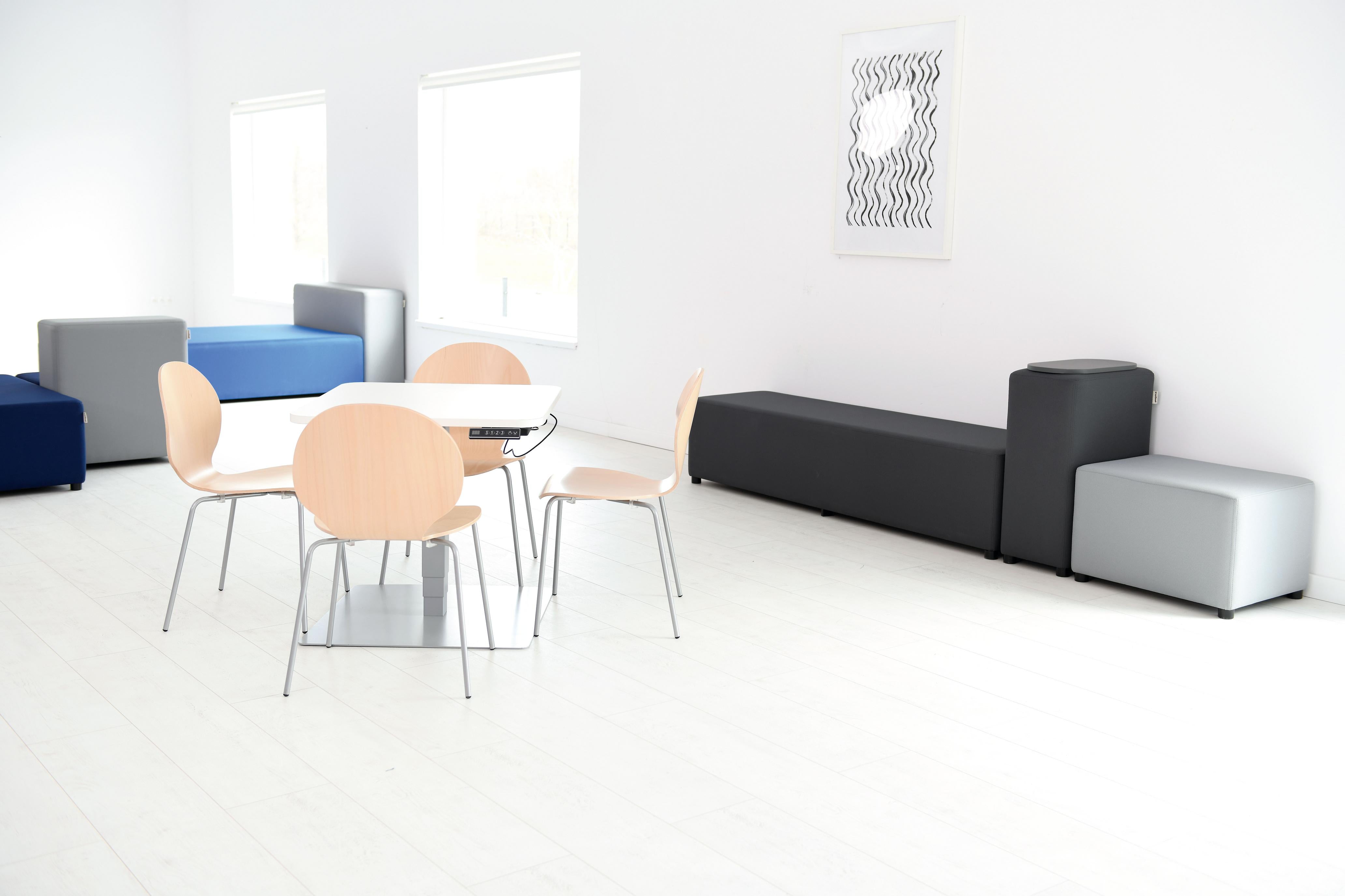 Modulare Sitzlandschaft mit Tisch und Stühlen im Raum.