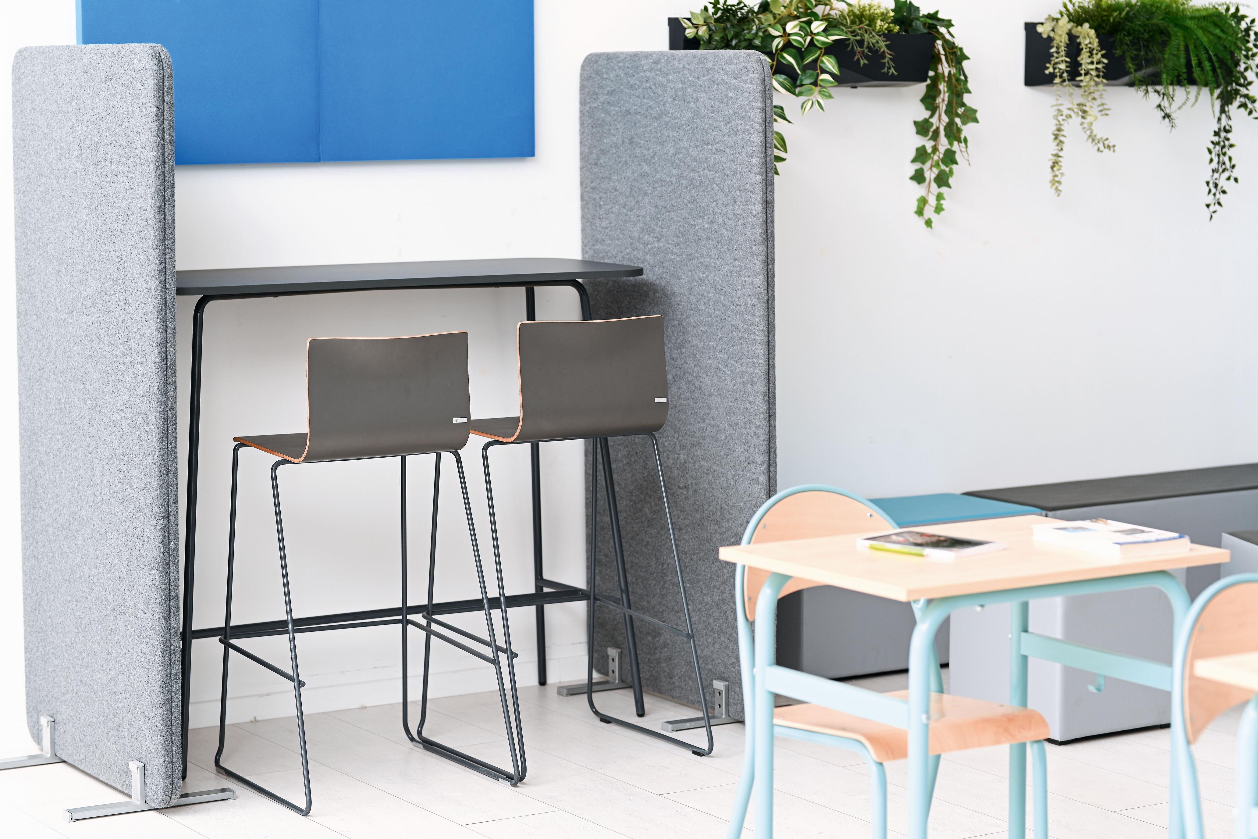 Hochtisch mit grauen Stühlen im modernen Raum.