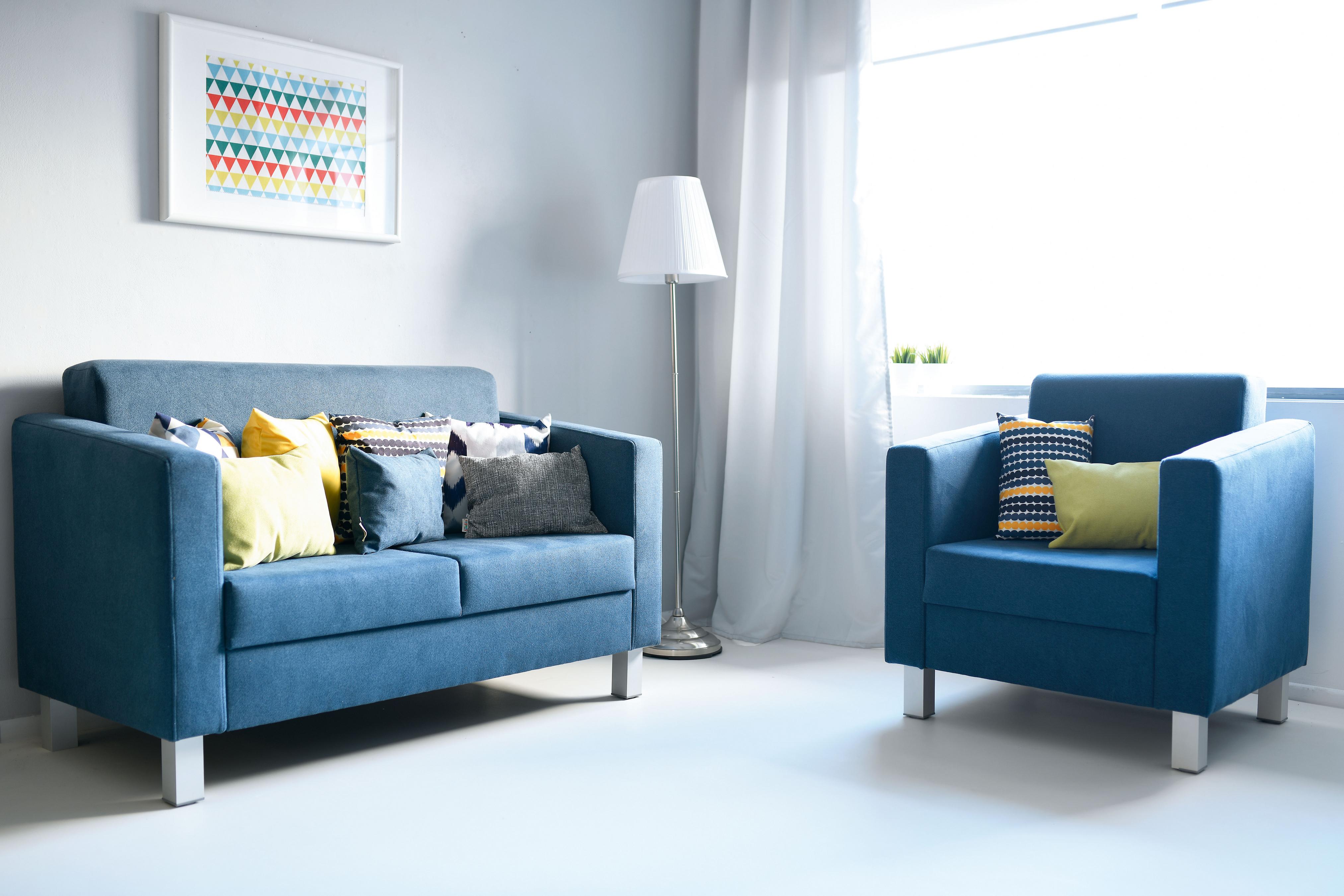 Kissen für Sitzlandschaft auf blauem Sofa und Sessel.