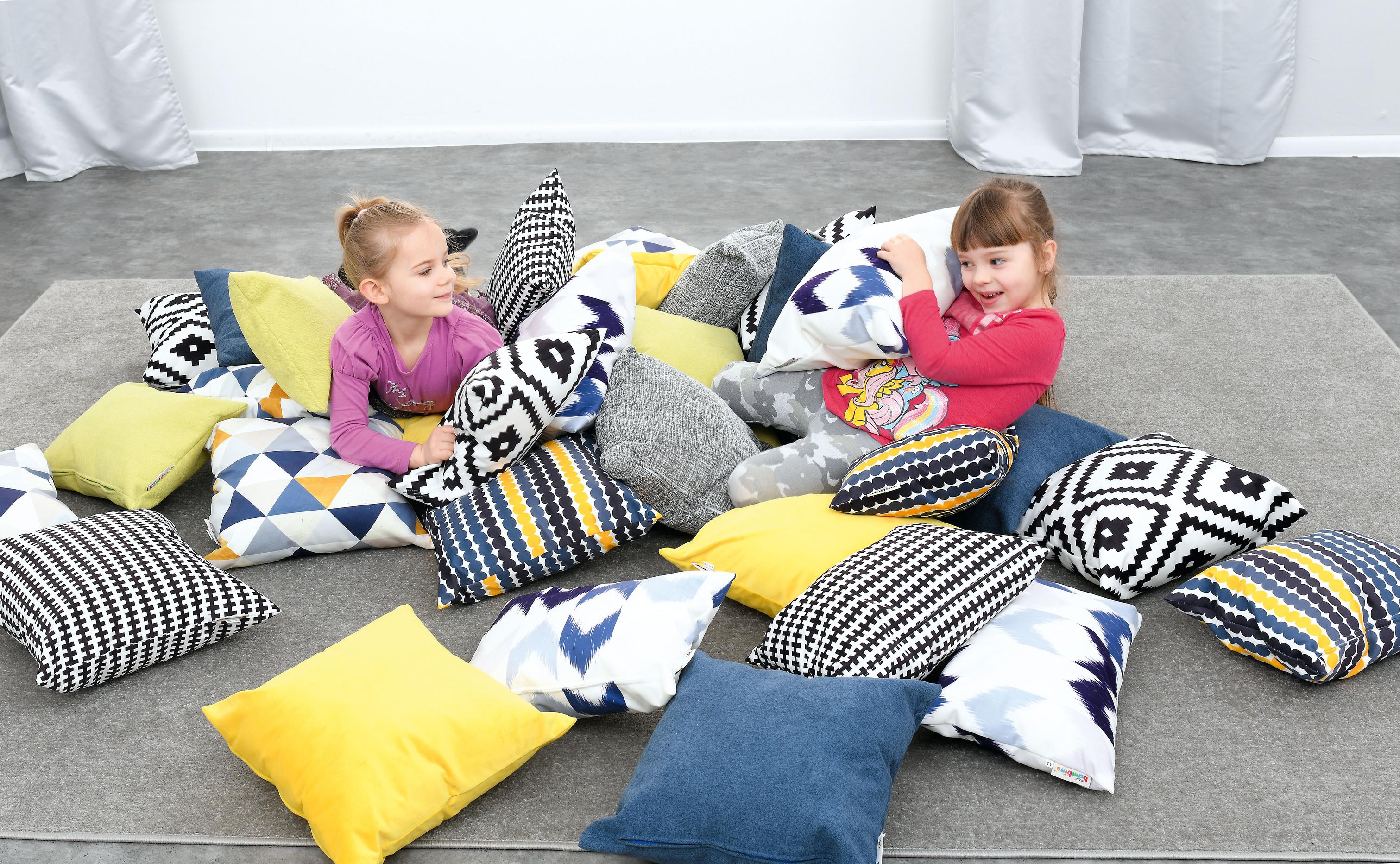 Kissen für Sitzlandschaft mit spielenden Kindern im Raum.