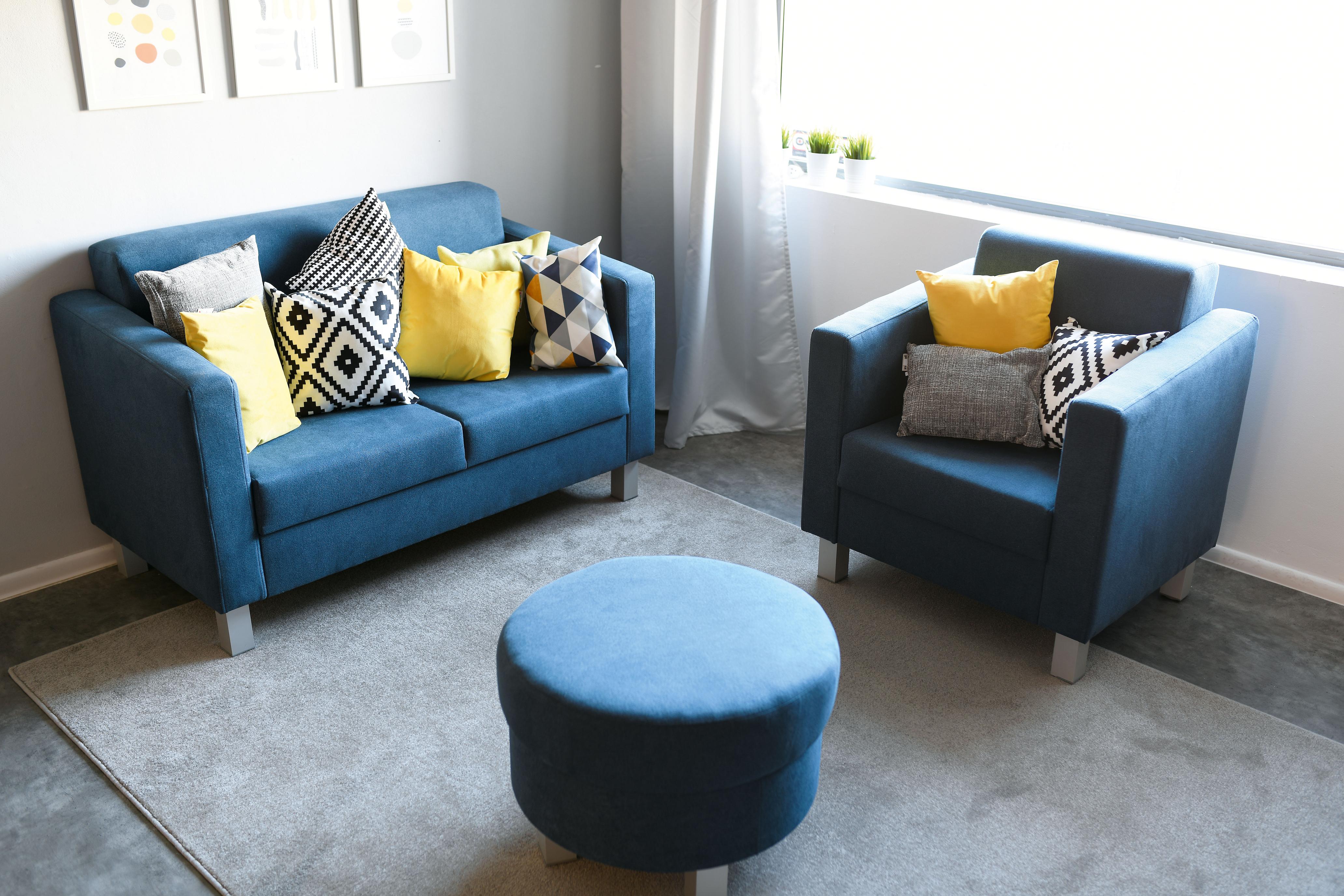 Kissen für Sitzlandschaft auf blauen Möbeln angeordnet.