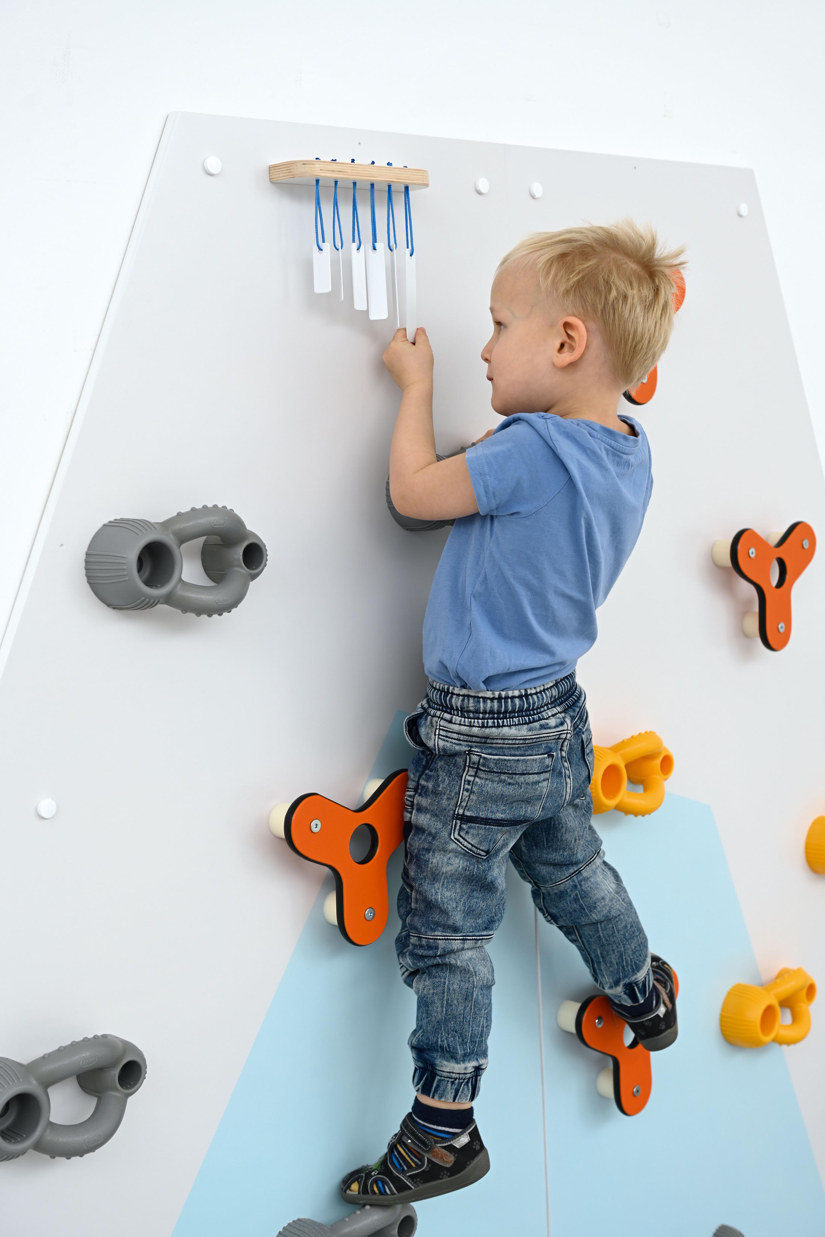 Kind klettert an Kletterwand für Kita, integrative Klänge.