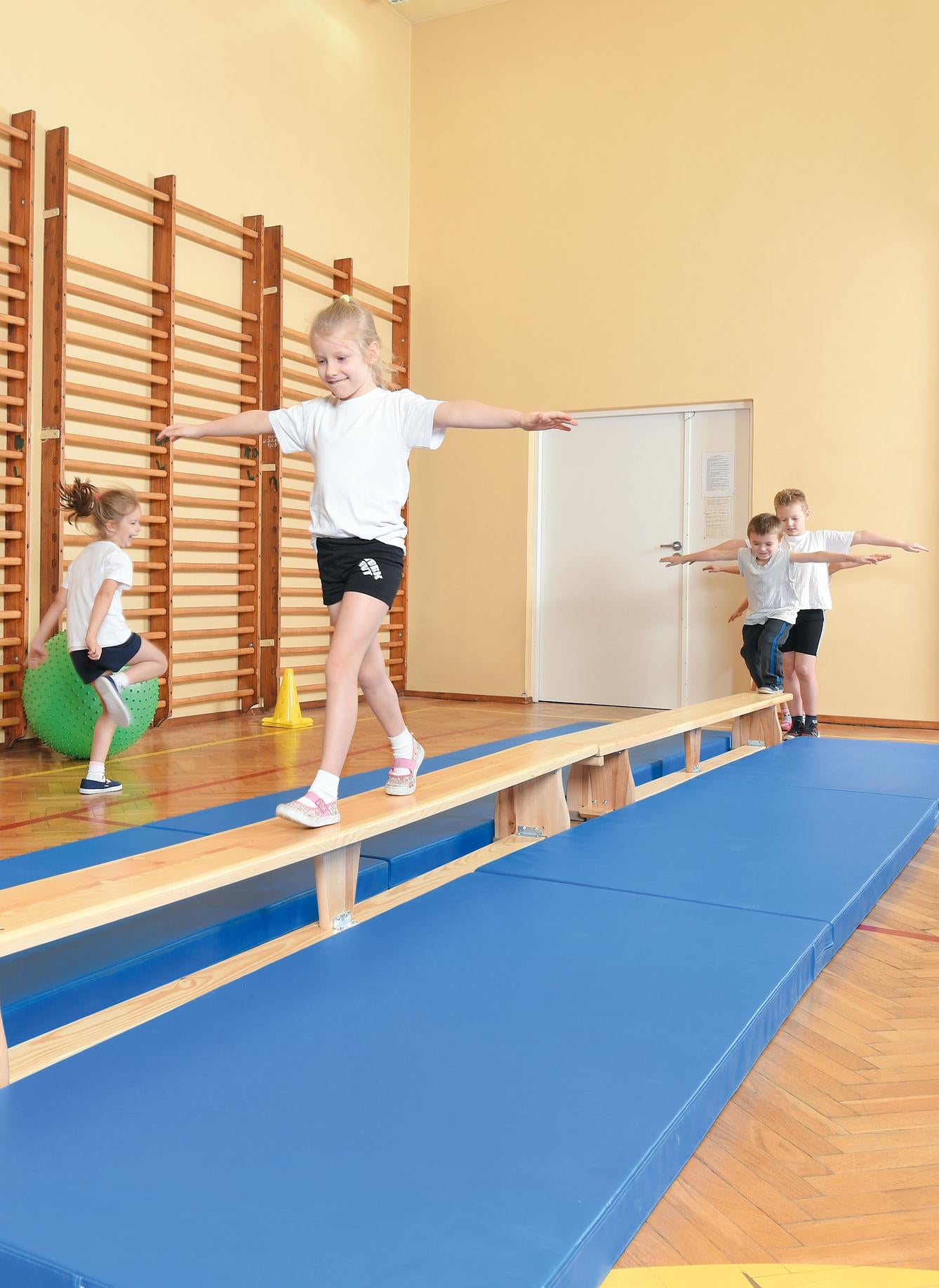 Kinder balancieren auf der Turnbank 3 m, sportlich aktiv.