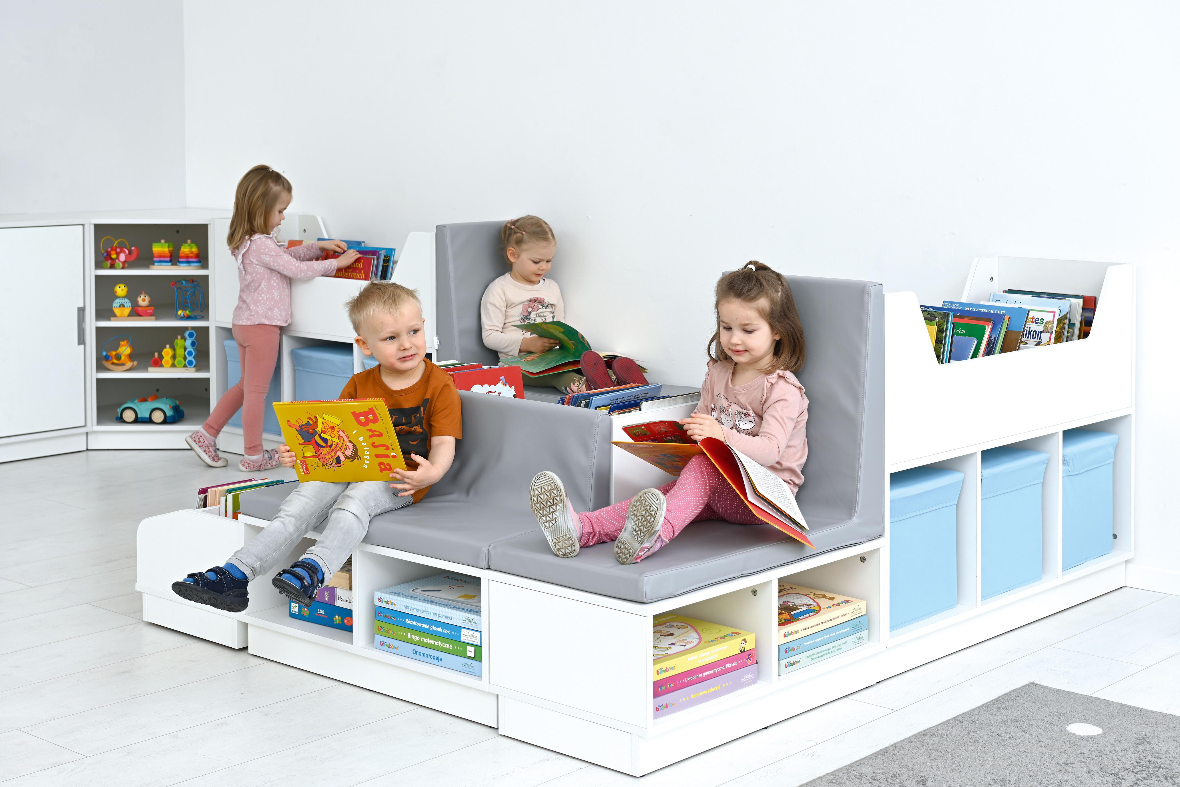 Kinder lesen Bücher auf einer bequemen Bücherbank. - Produkt wird im Kindergarten oder Schule genutzt.