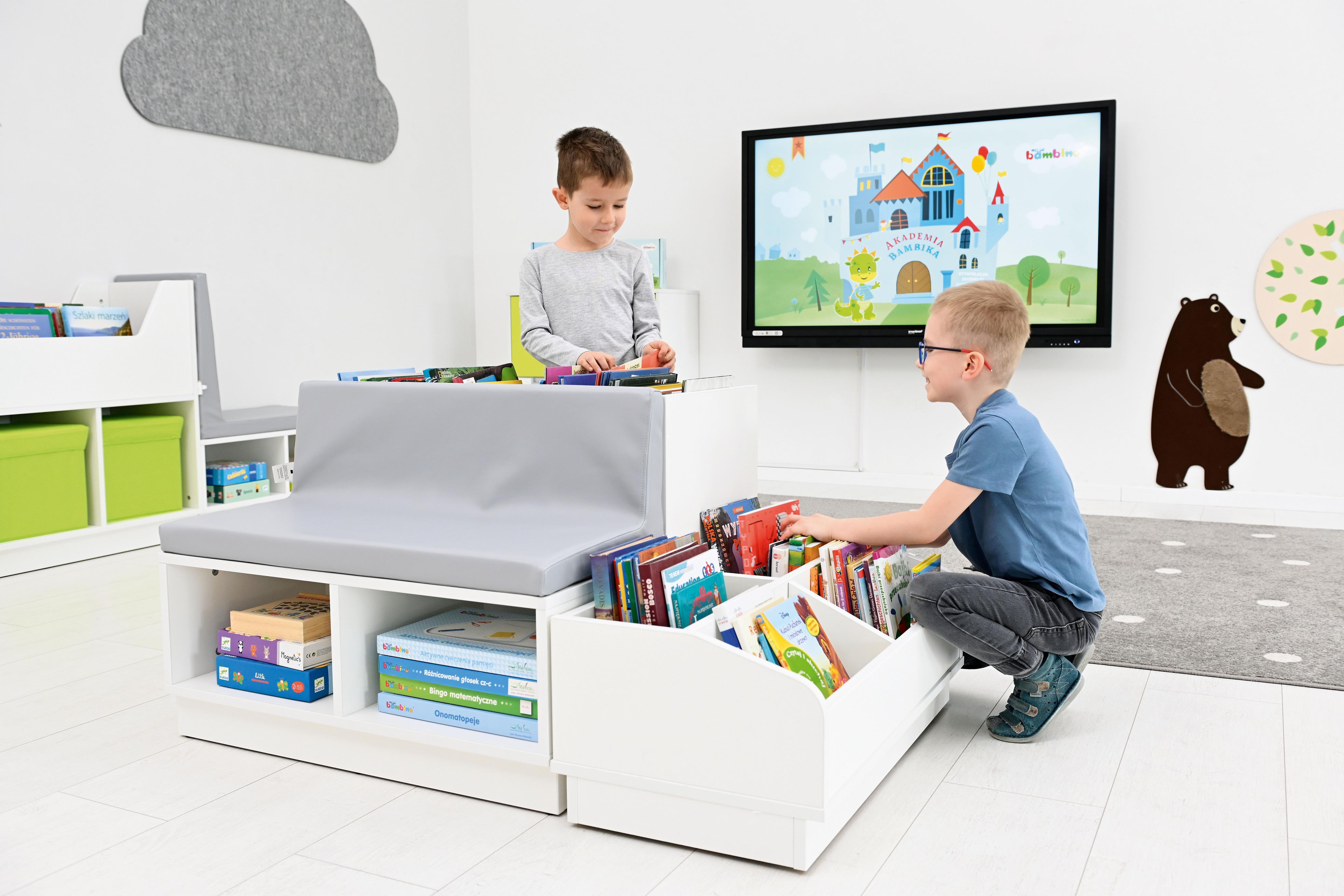 Kinder nutzen die Bücherbank in gemütlicher Leseecke. - Produkt wird im Kindergarten oder Schule genutzt.