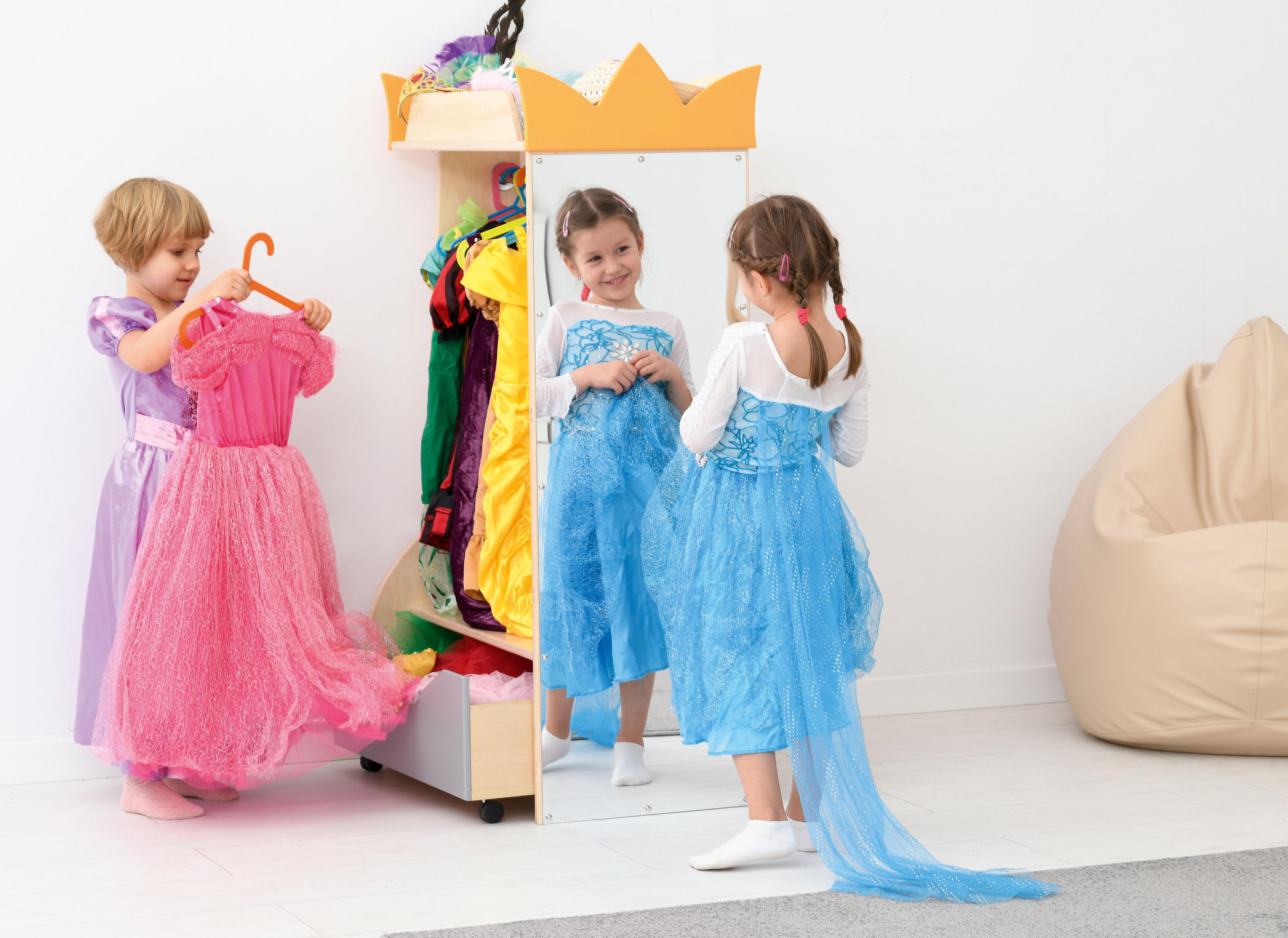 Kinder verkleiden sich an der Kindergarten Garderobe mit großem Spiegel