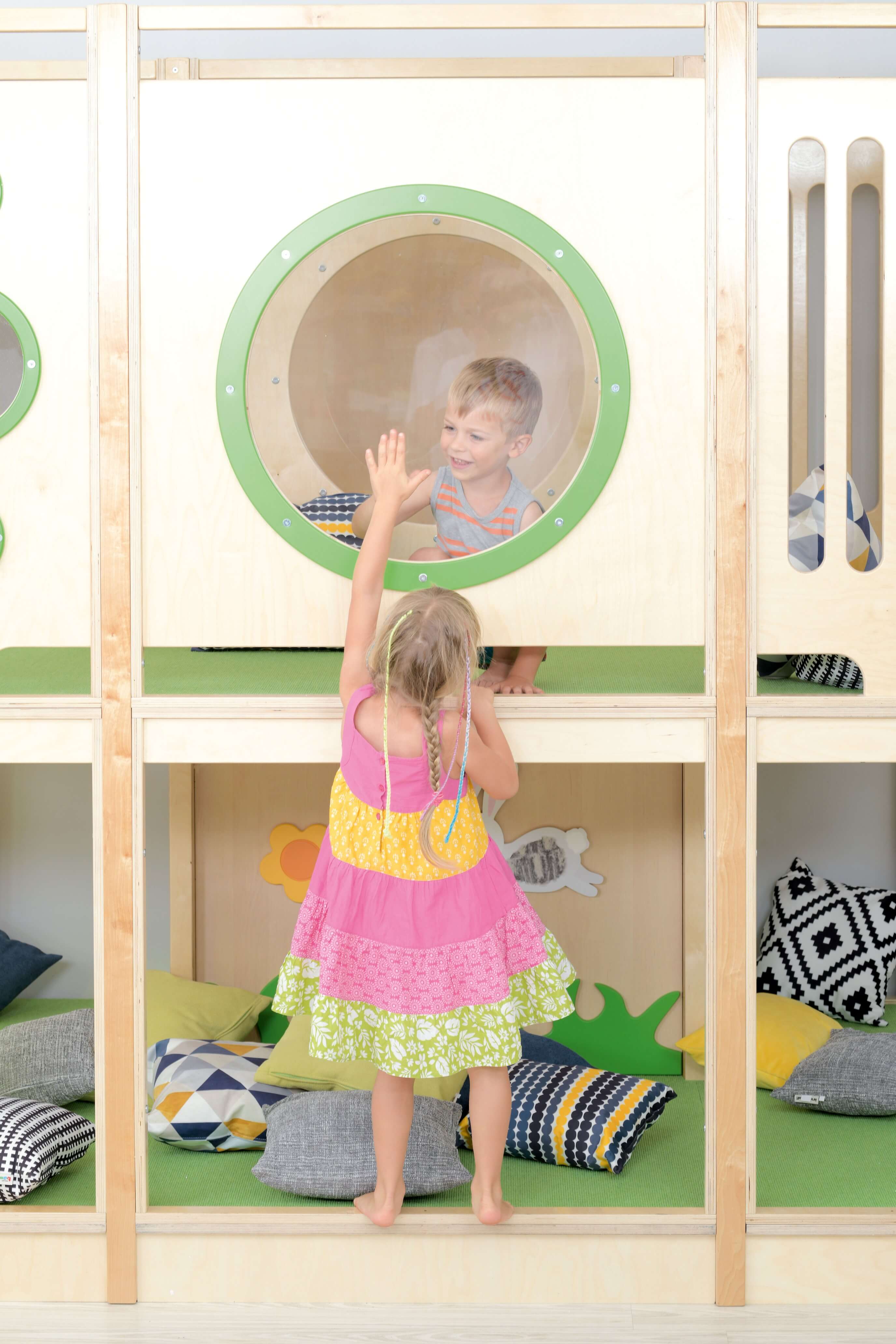 Kindergarten Hochebene Ben Detailansicht von Bullauge mit Kindern