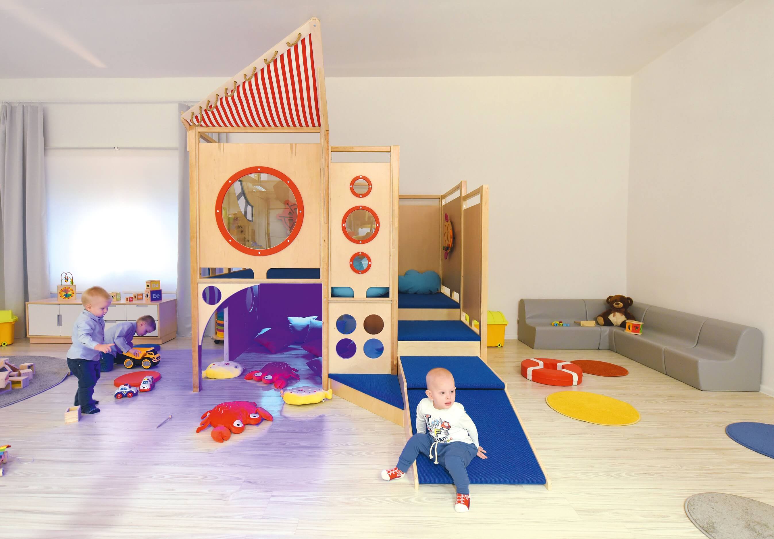 Kindergarten Spielburg Neptun im Gruppenraum von vorne mit Krippenkindern