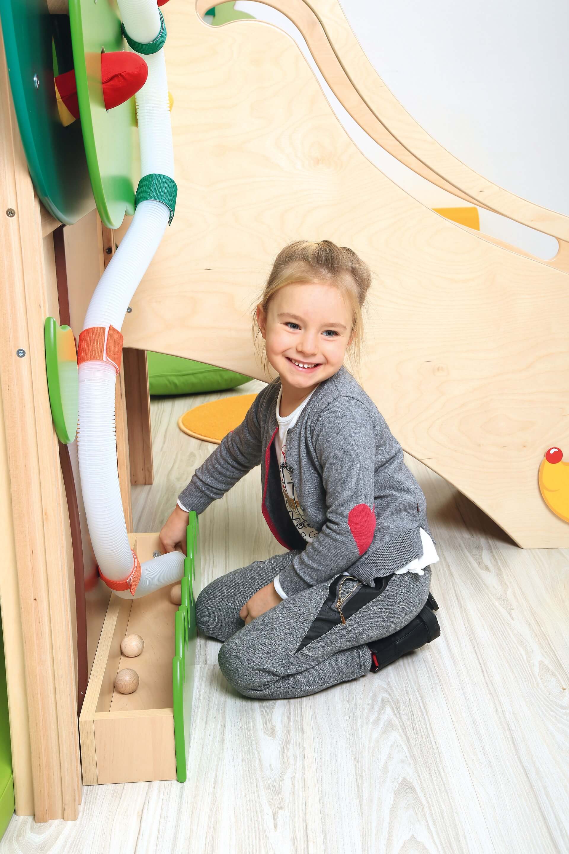 Kindergarten Spielpodest Baumhaus Kind spielt mit Kugelbahn