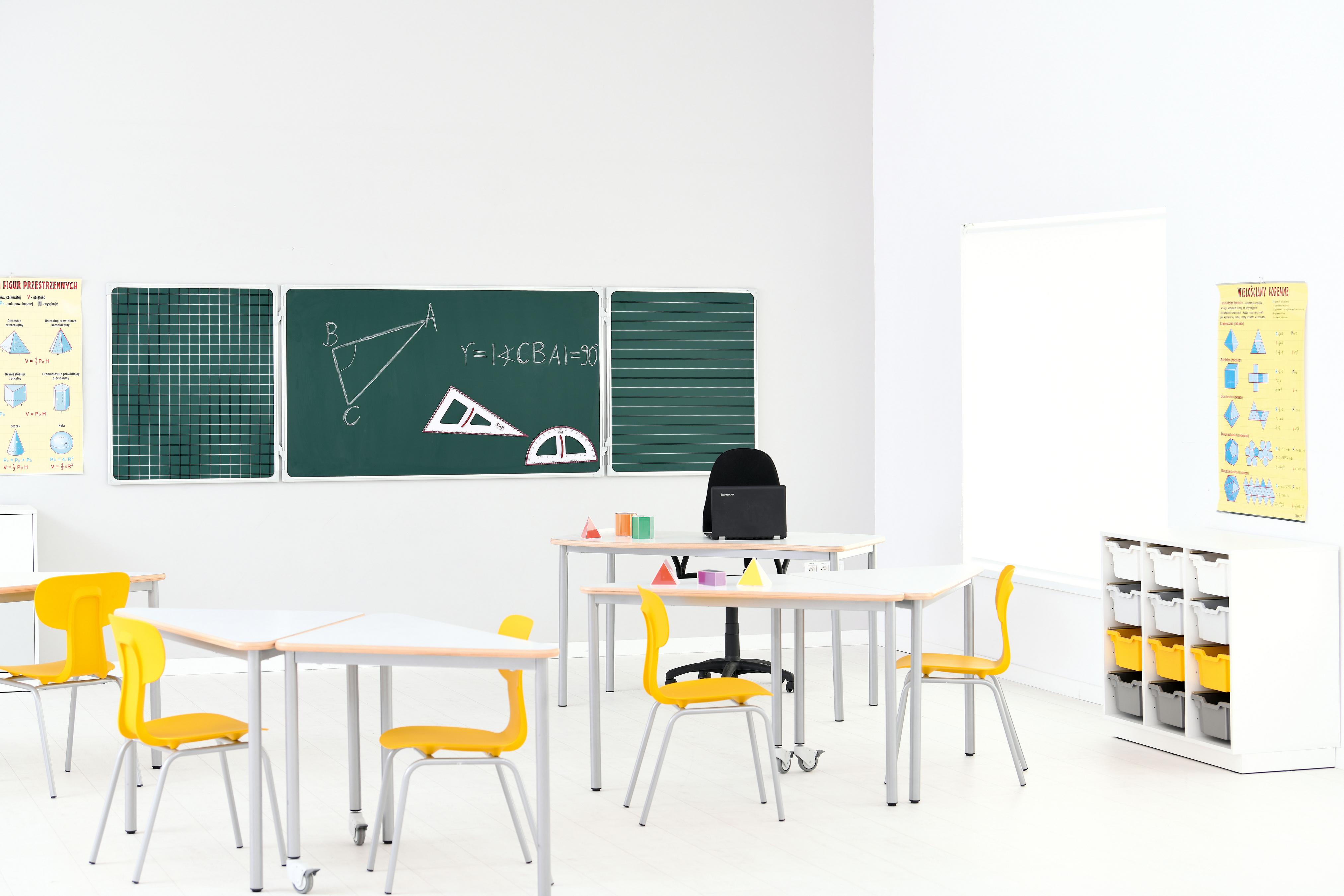 Schülerstuhl Ergo um gelbe Tische im Klassenraum arrangiert.