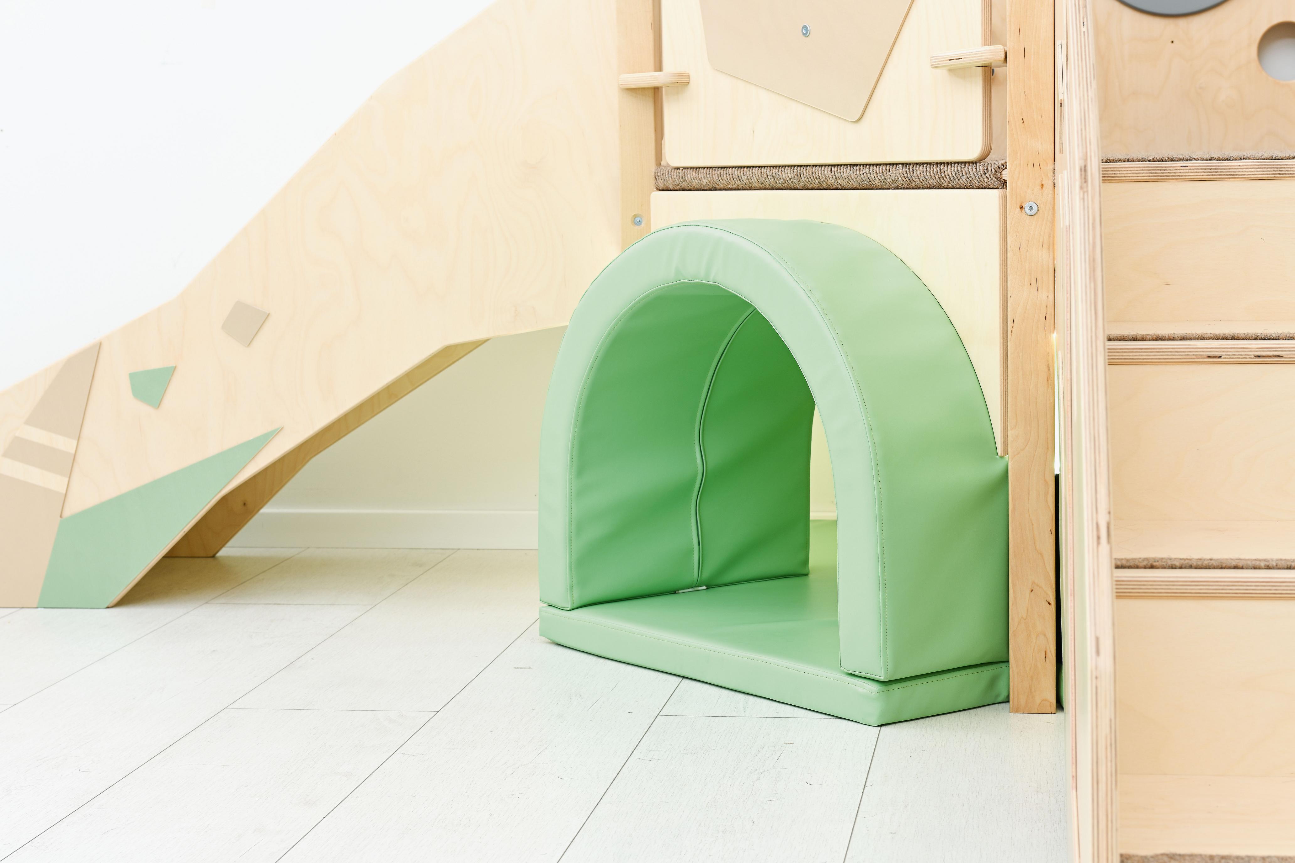 Sensorische Spielecke mit Tunnel auf Hochebene im Raum.