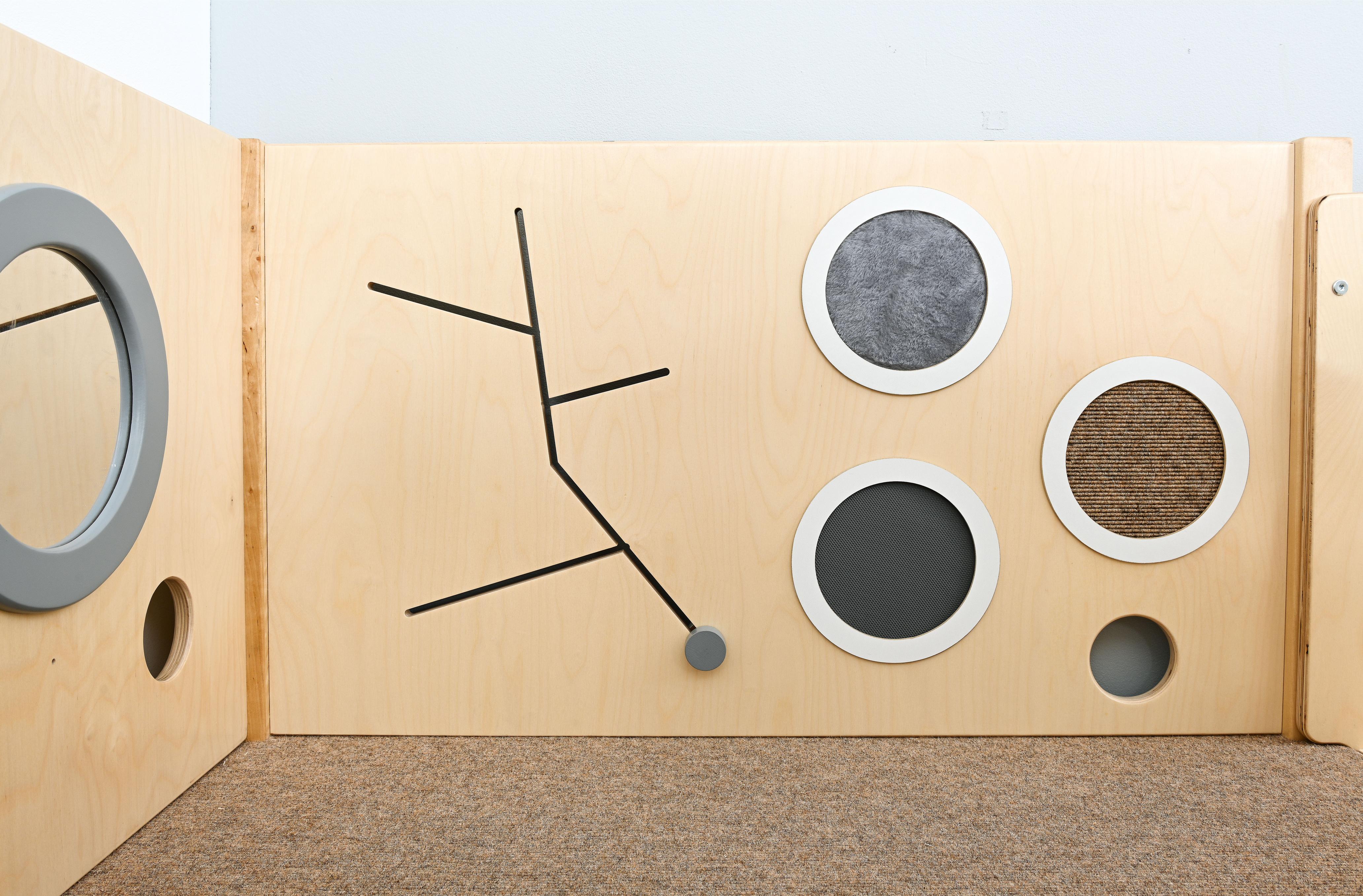 Sensorische Spielecke mit strukturierten Oberflächen und Holzdesign.