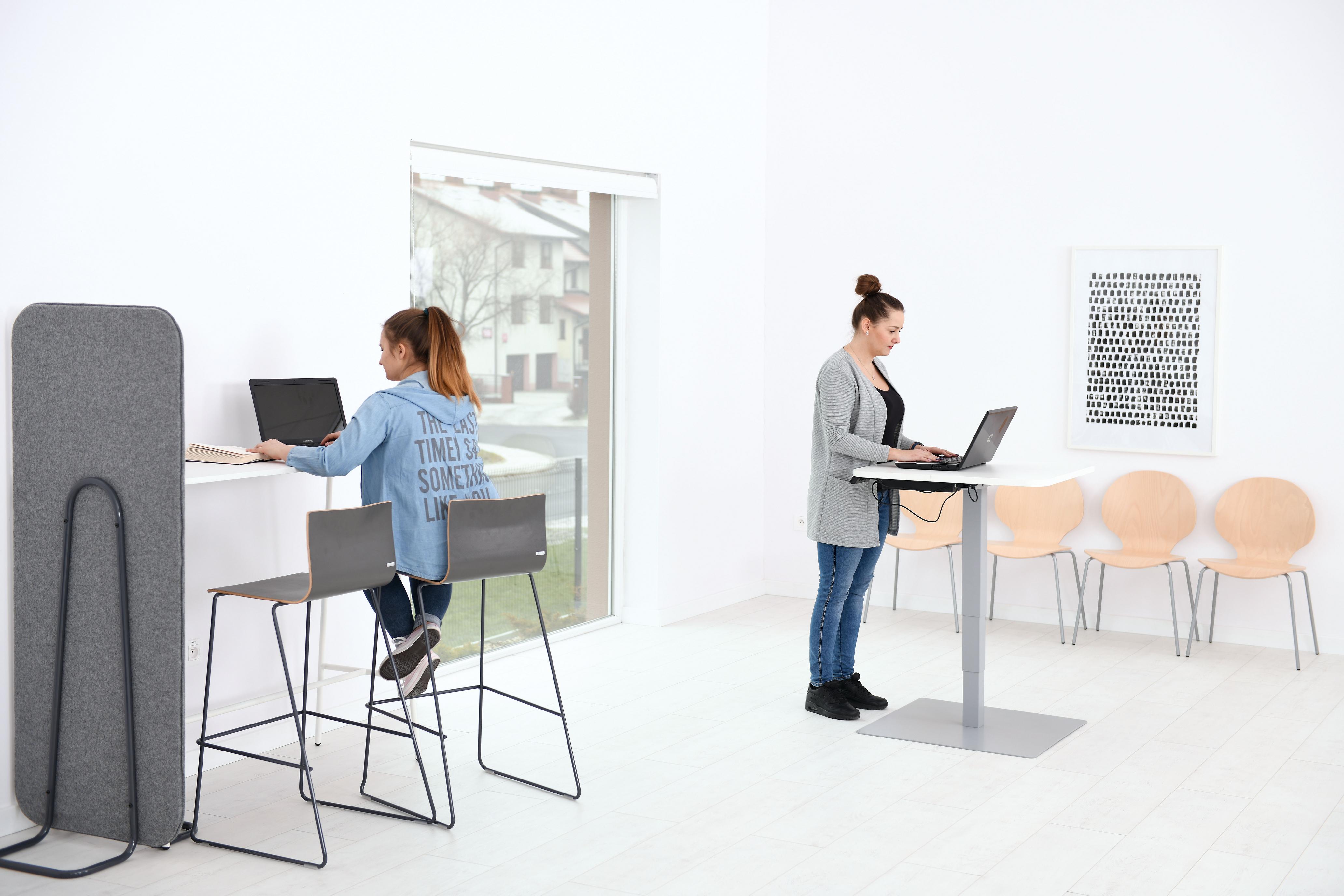 Zwei Personen arbeiten auf Barhocker Cool an Laptops.