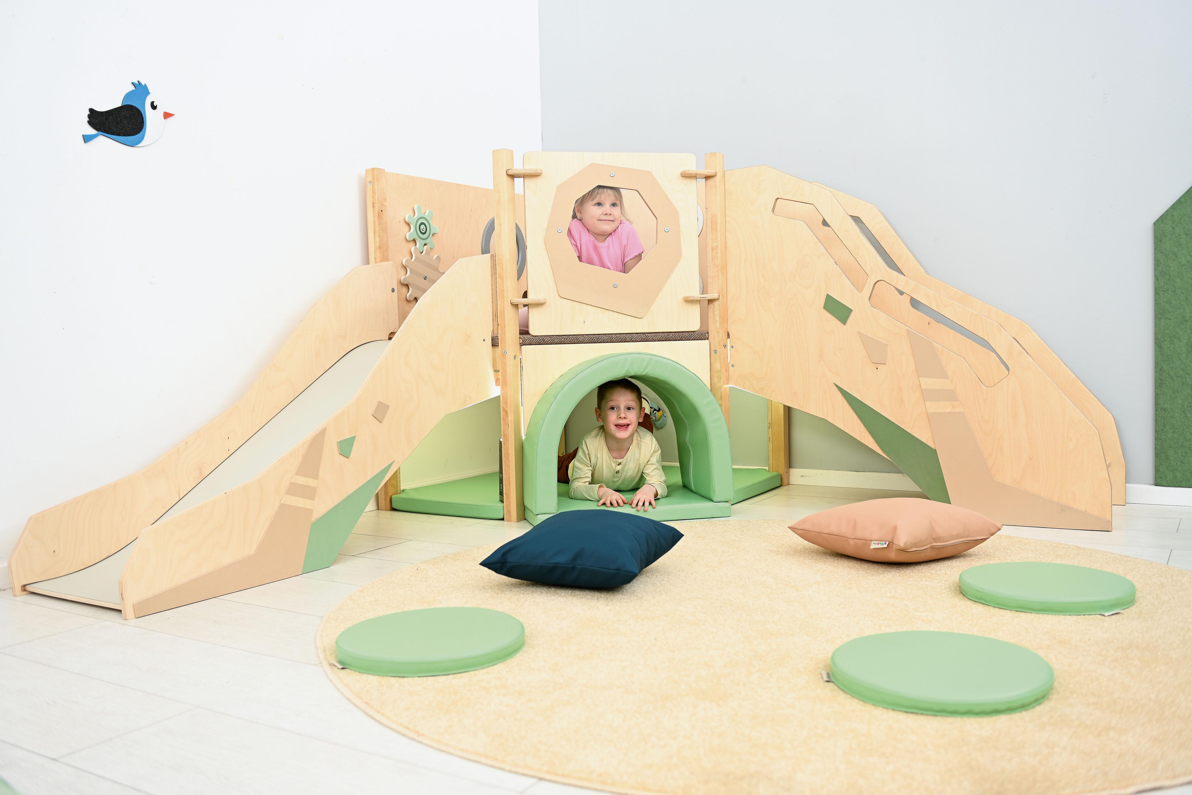 Kinder spielen in sensorischer Spielecke auf Hochebene.