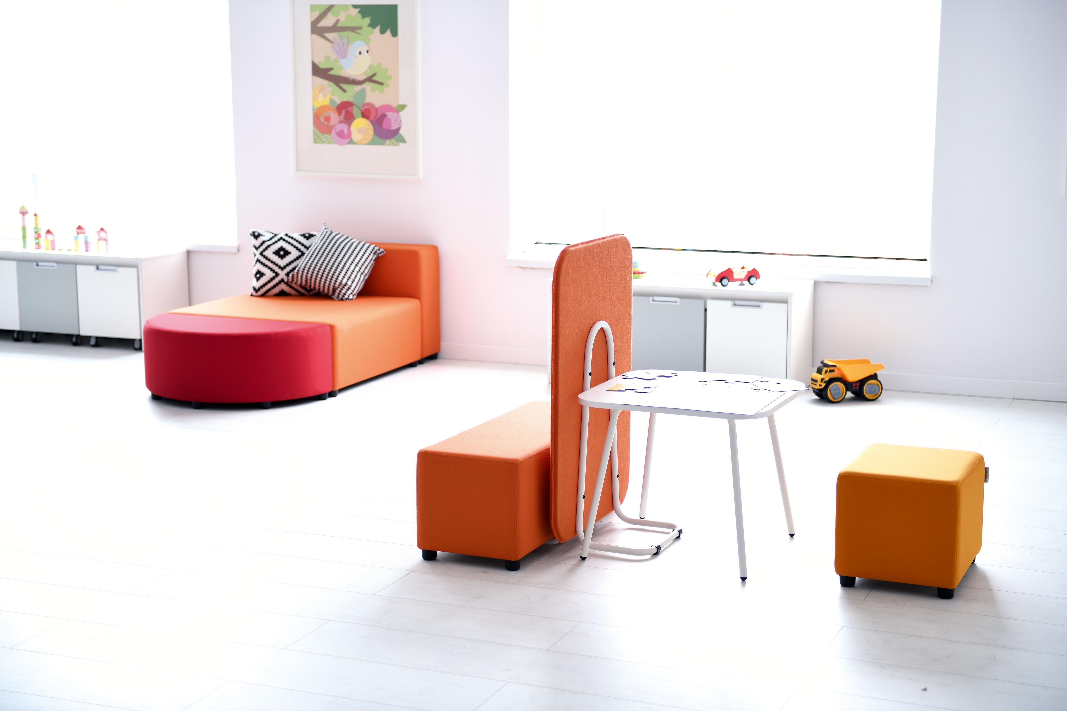 Modulare Sitzlandschaften und Akustikpaneele im Gruppenraum.