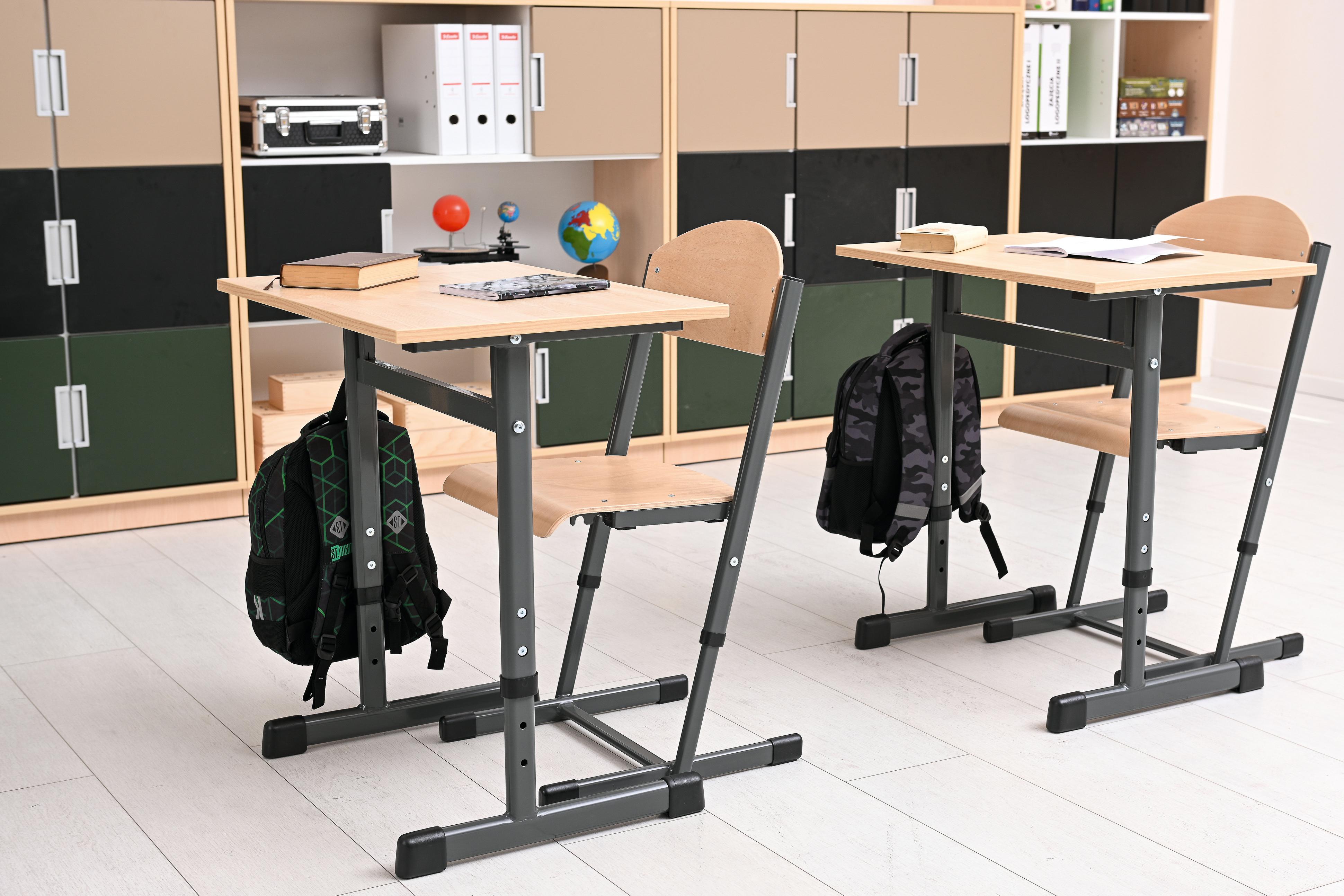 Zwei höhenverstellbare Einzeltische im Klassenzimmer.